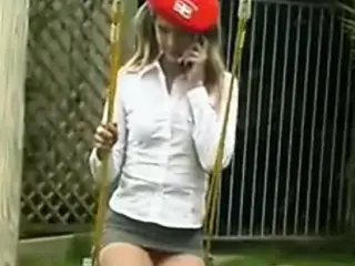Teen in extreme mini skirt outdoor on a swing