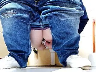 Hot MILF in jeans pissing in a public restroom