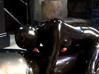 couple in black latex catsuit mask and the blowjob girl