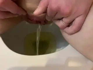 She pees in the toilet and touches her pussy